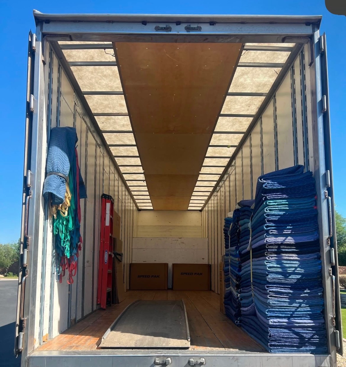 A clean moving truck stocked with blankets, straps, and loading equipment