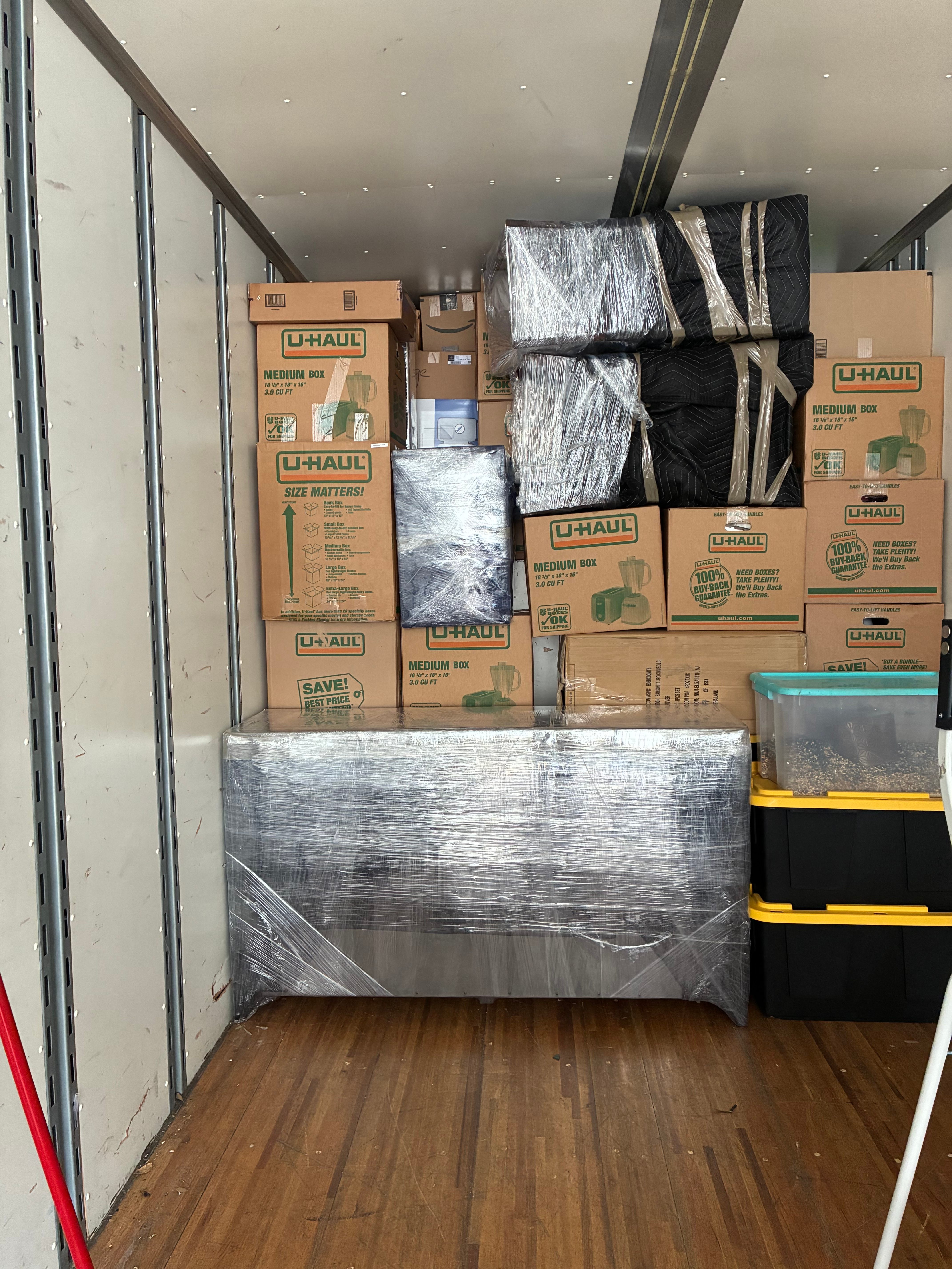 Boxes and wrapped furniture securely loaded inside a moving truck